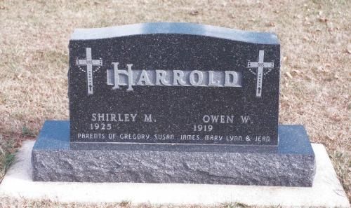 A black granite headstone for the Harrold family, inscribed with the names Shirley M. and Owen W. and two crosses.