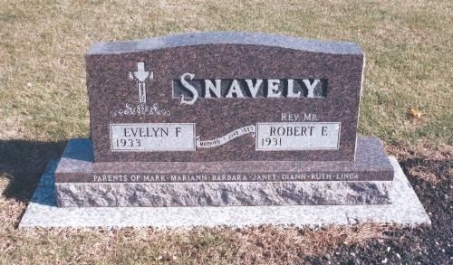A granite Snavely family headstone in a cemetery listing Evelyn F. and Rev. Robert E. Snavely and their children.