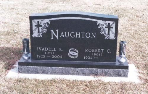 A black polished granite tombstone for the Naughton family with engravings of two crosses and interlocking wedding rings.