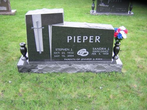 A dark granite headstone engraved with 