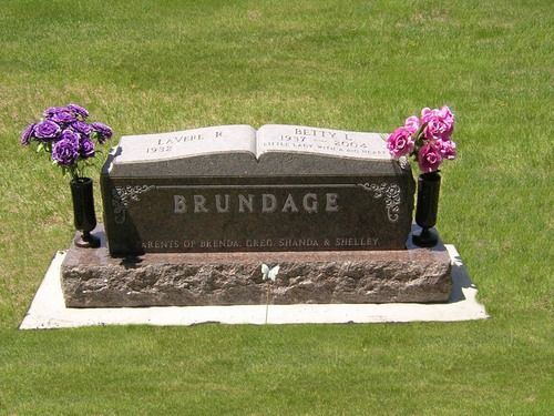 A grey, open-book style gravestone marked 