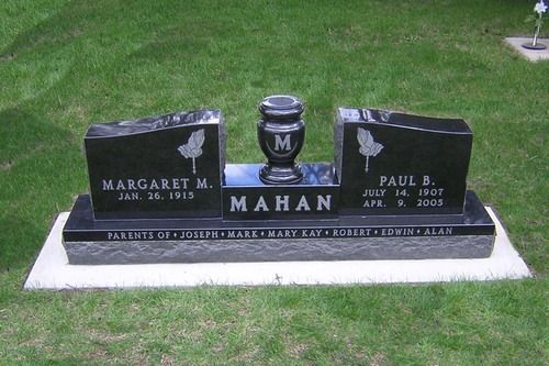 Black granite double headstone for the Mahan family with an urn in the center, set on a concrete base in a grassy lawn.