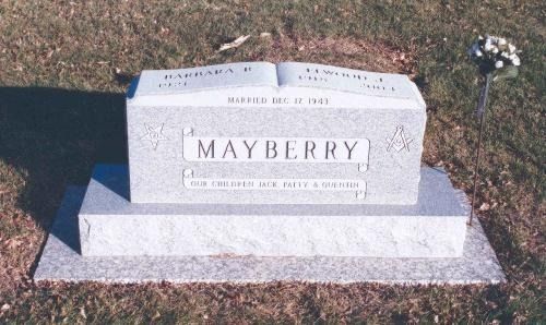 A light gray stone grave marker for the Mayberry family, featuring an engraved open book design, situated on a lawn.