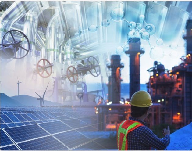 A man in a hard hat is standing in front of a factory with solar panels.
