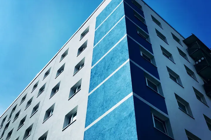 Um prédio azul e branco com um céu azul ao fundo