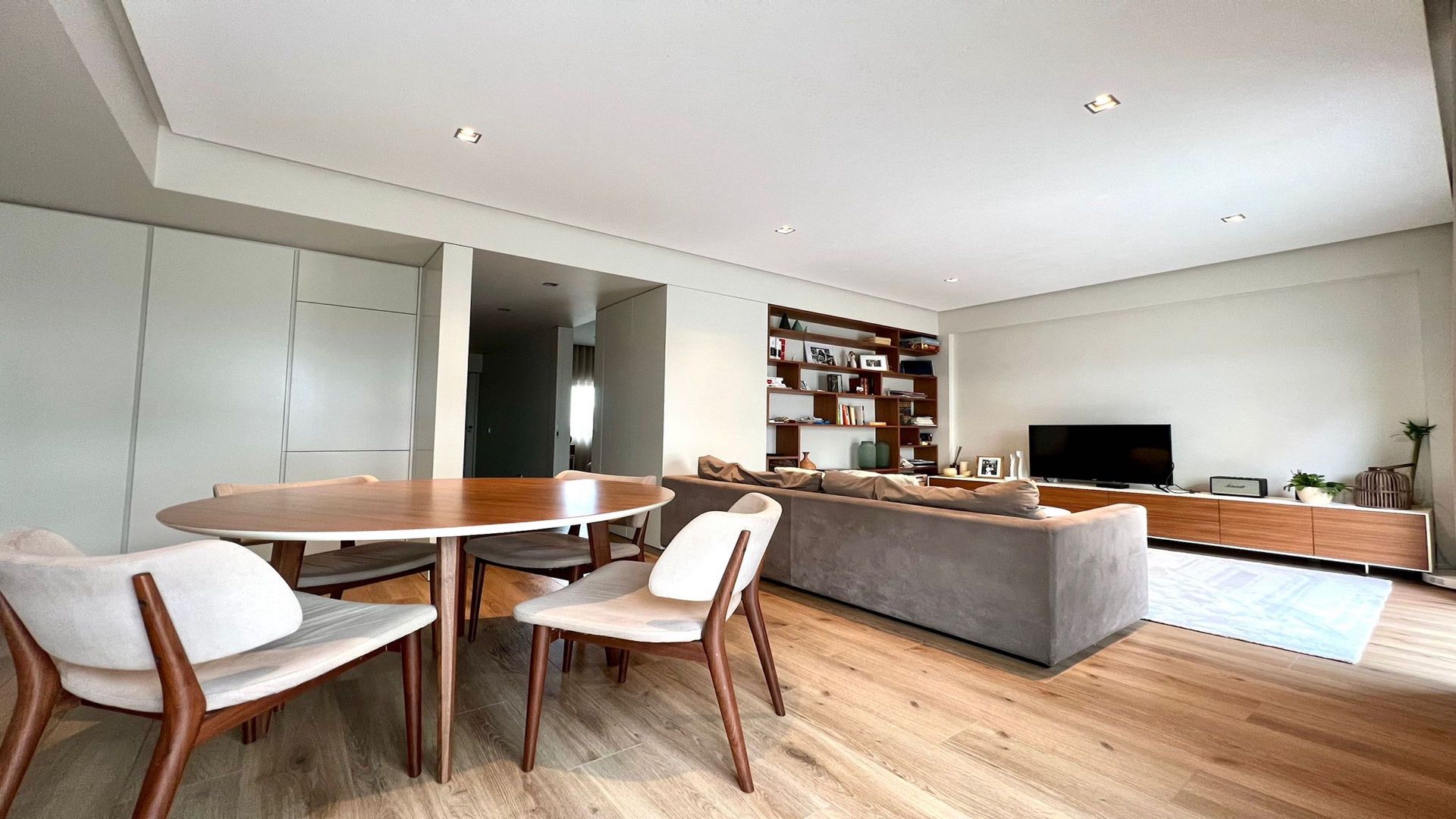 Uma sala de estar com uma mesa, cadeiras e um sofá.