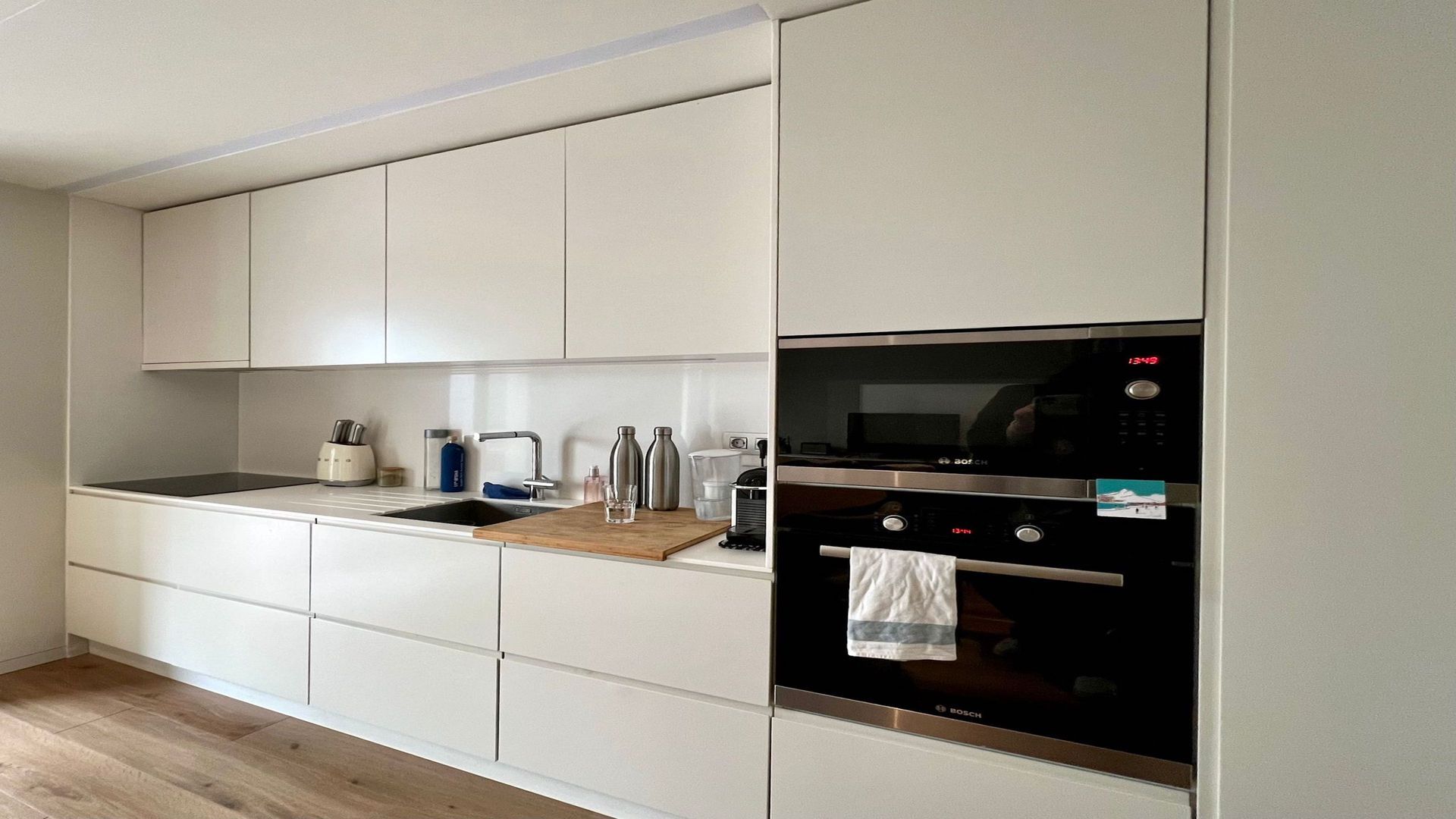 Uma cozinha com armários brancos e eletrodomésticos de aço inoxidável.