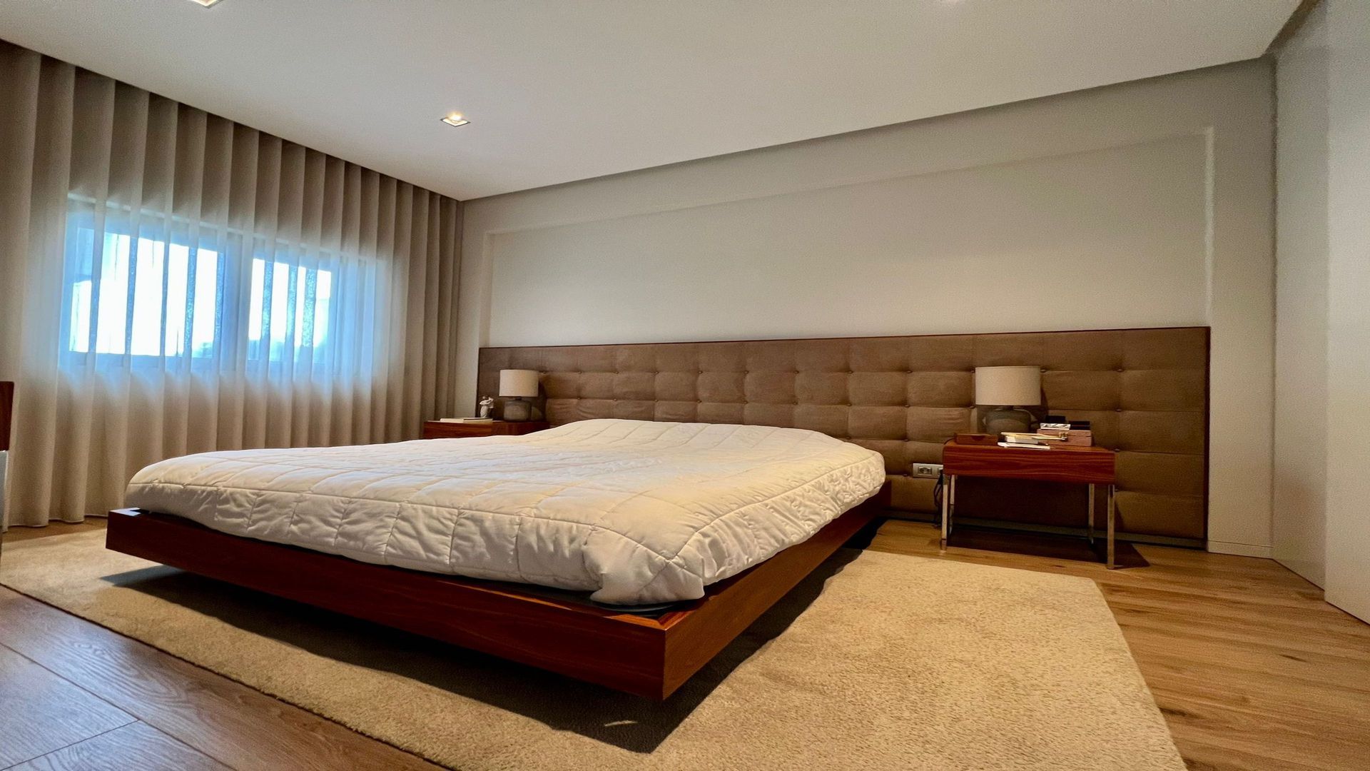 Há uma cama grande no meio do quarto.