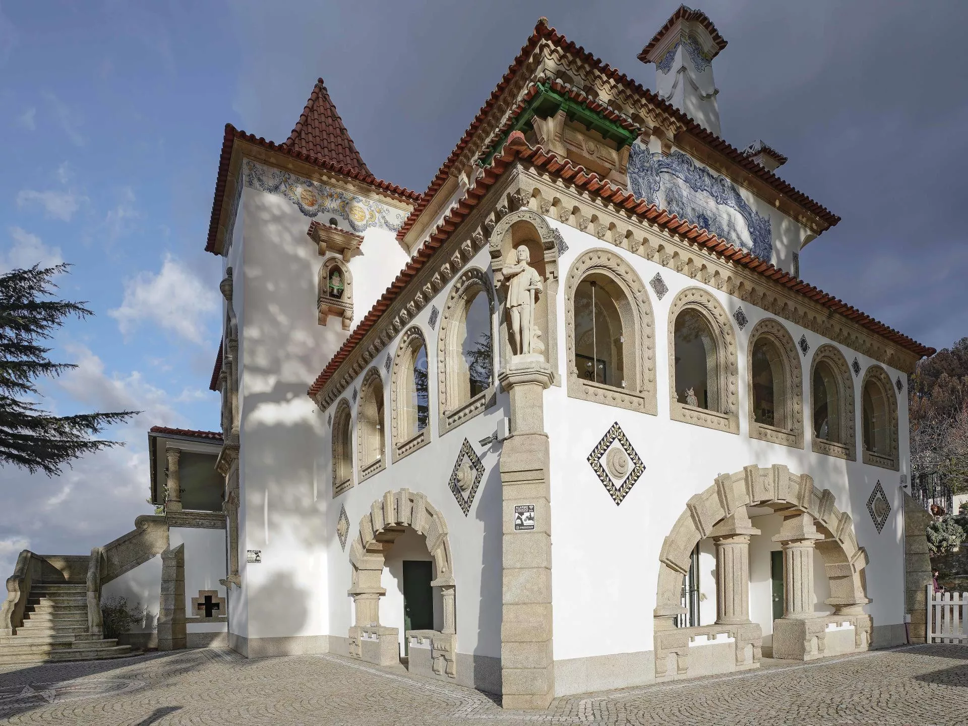 Um grande edifício branco com uma estátua na frente