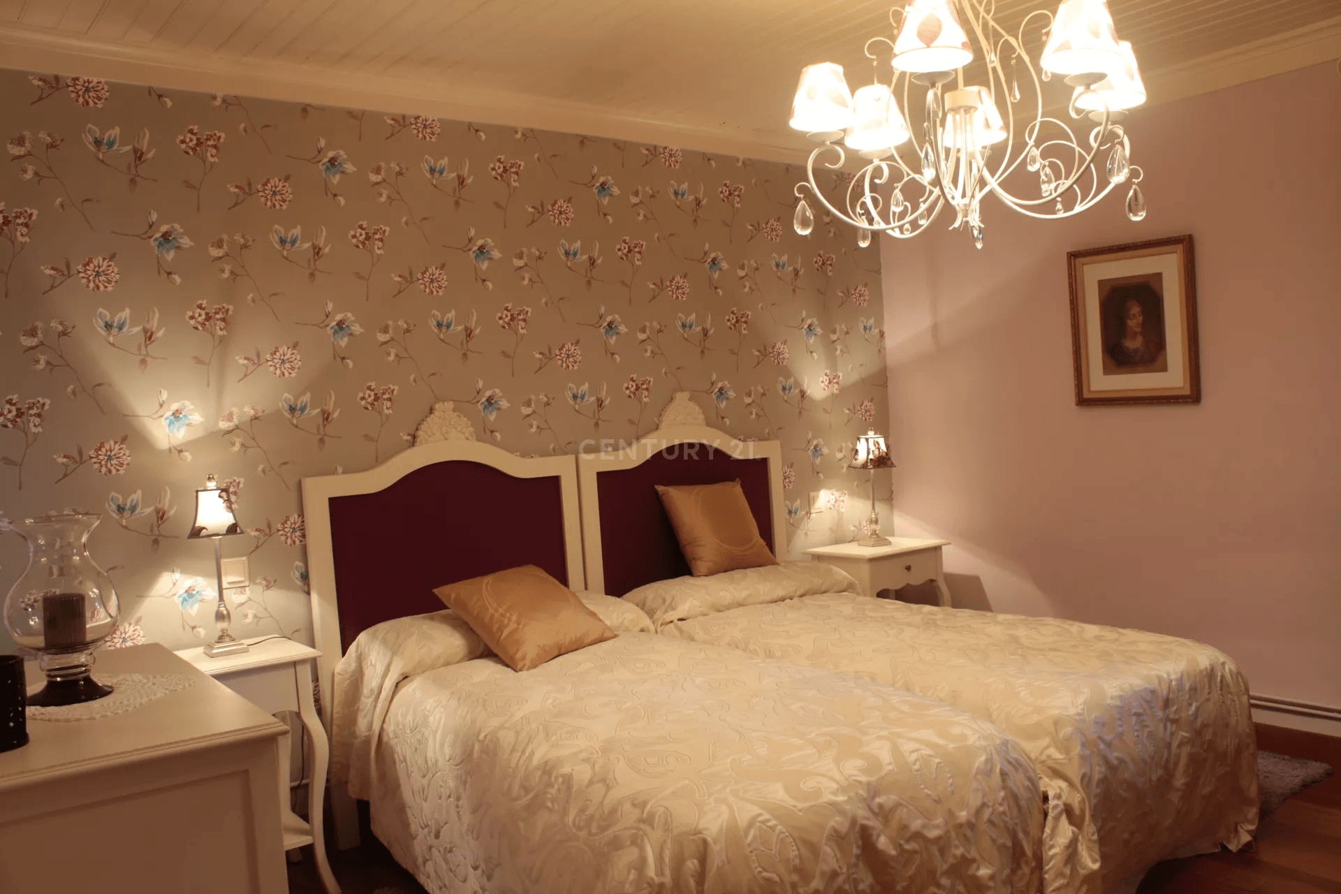 Um quarto com duas camas e um lustre pendurado no teto