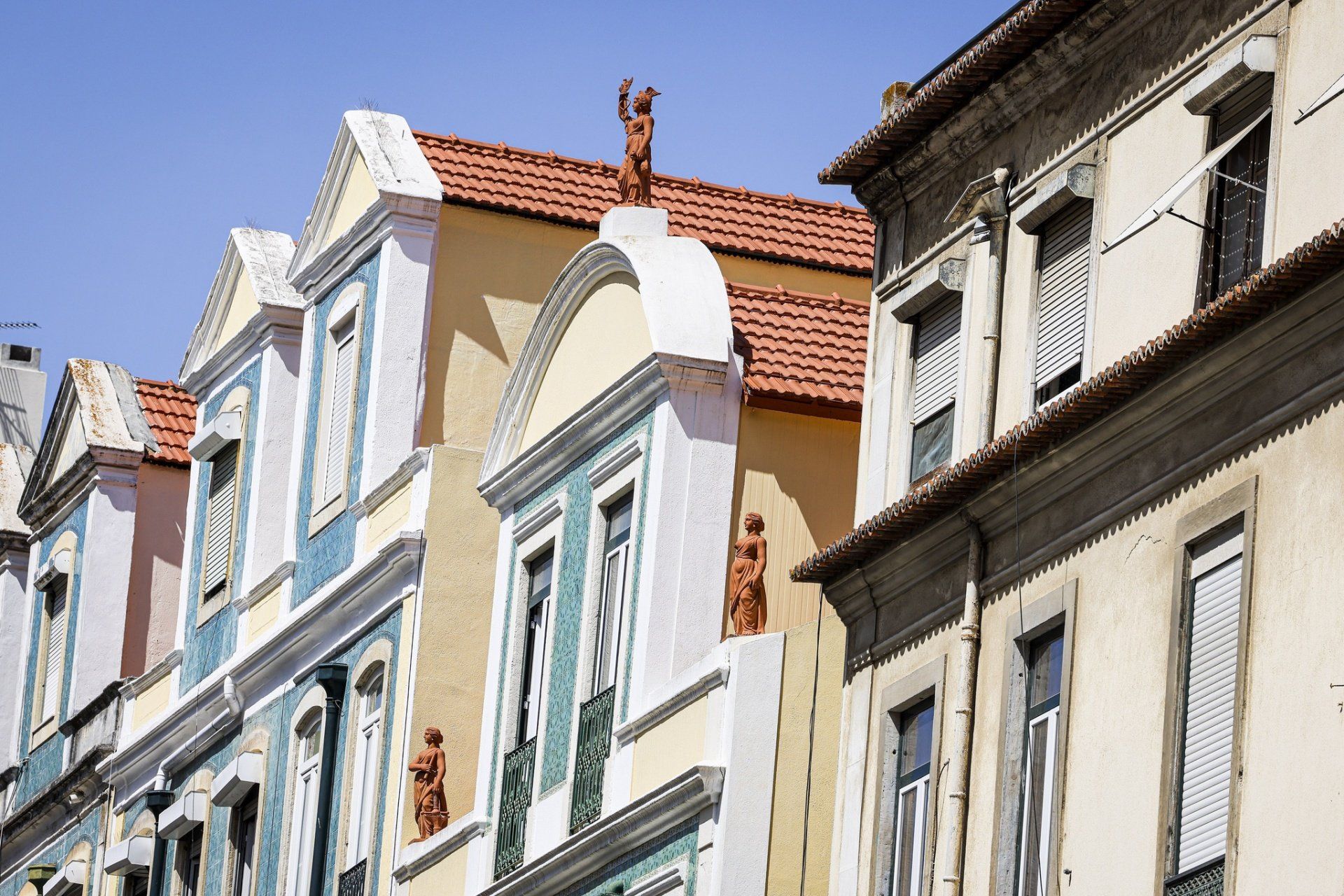 Uma fileira de edifícios com uma estátua no topo de um deles