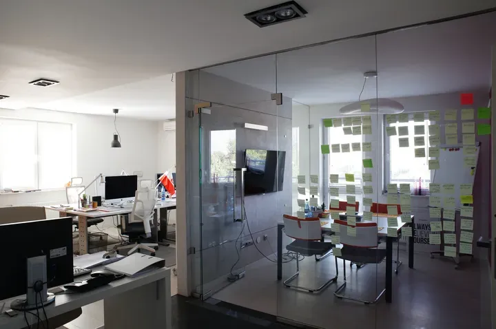 Uma sala com uma parede de vidro e uma mesa e cadeiras nela