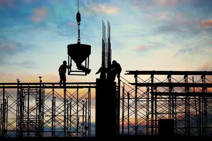 Um grupo de trabalhadores da construção civil está trabalhando em um prédio em construção.