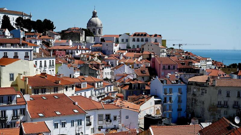 Uma cidade com uma cúpula no topo de uma colina com vista para o oceano