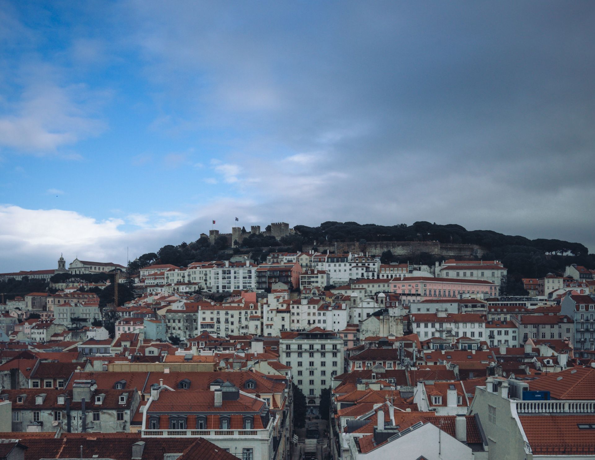 Uma vista aérea de uma cidade com uma colina ao fundo.
