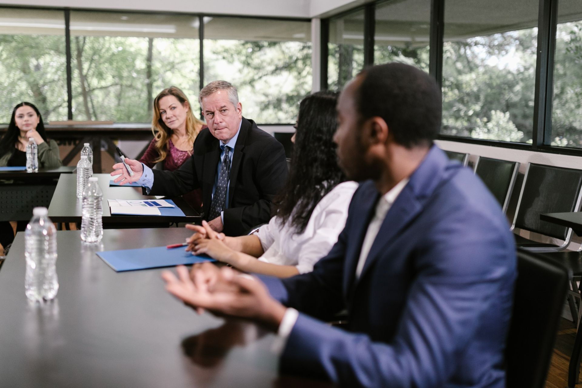 Um grupo de pessoas está sentado à mesa tendo uma reunião.