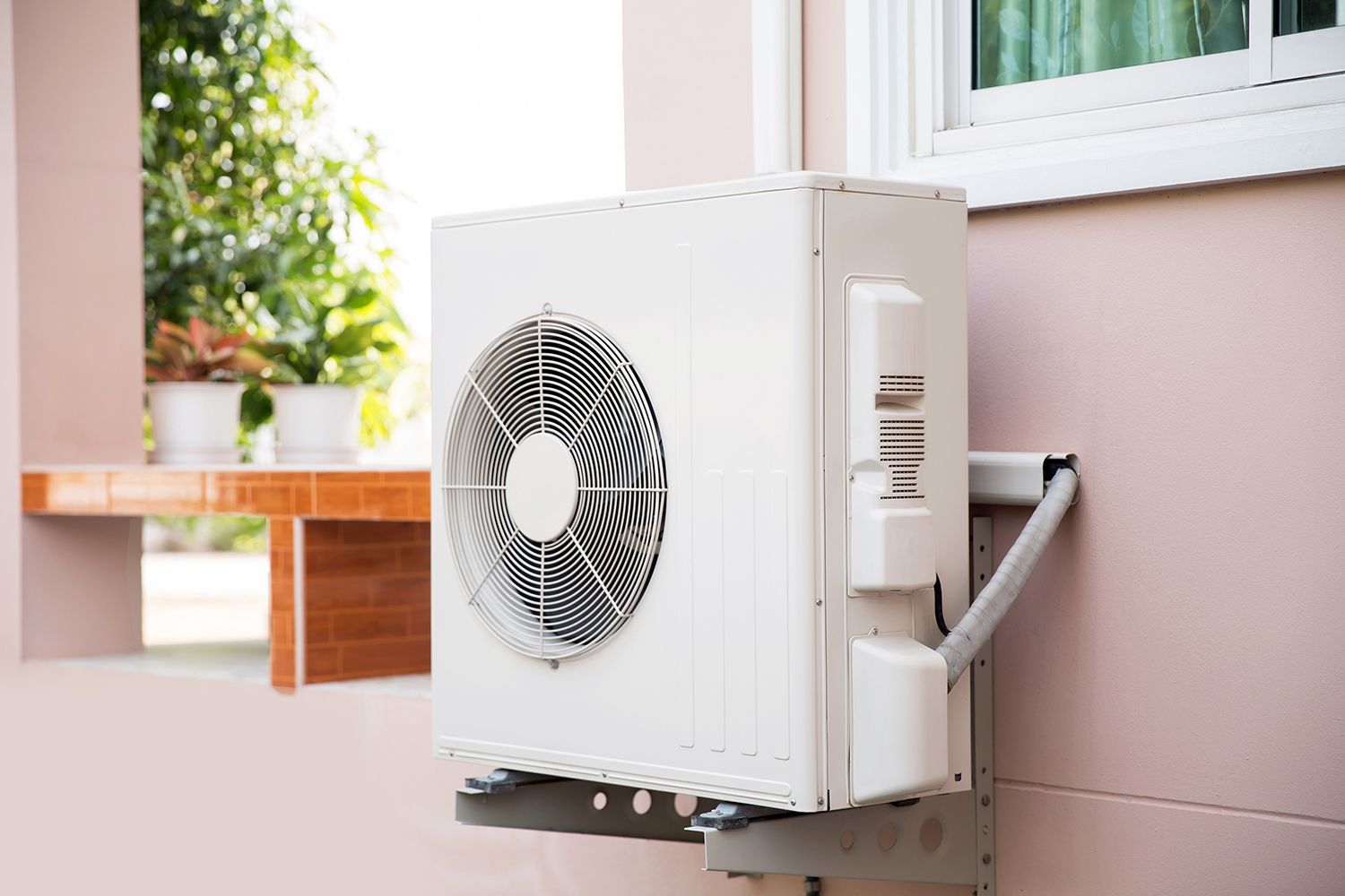 Close-up of an external split heat pump unit installed on the house.