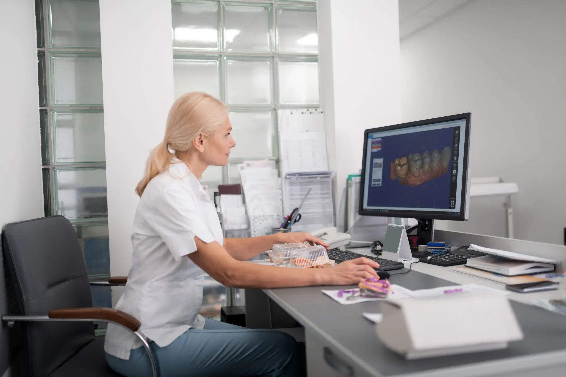 Person using computer, displaying 3D dental model, in a dental office. — AB Esthetic Dental Laboratory in Brisbane, QLD