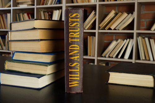 A stack of wills and trusts books on a table.