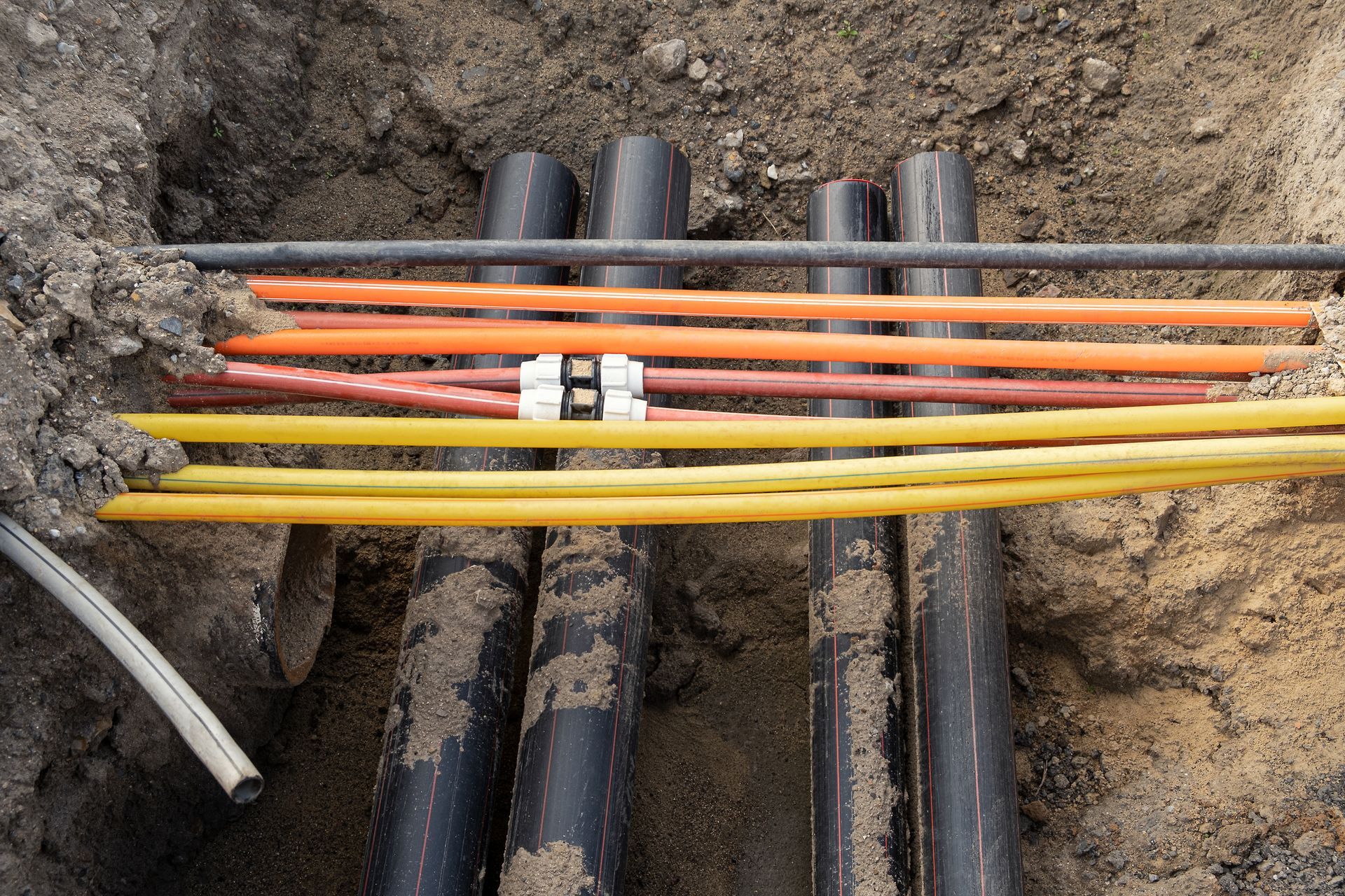 A bunch of electrical wires are laying in the dirt - Millville, CA - Concrete Construction Excavating Inc.