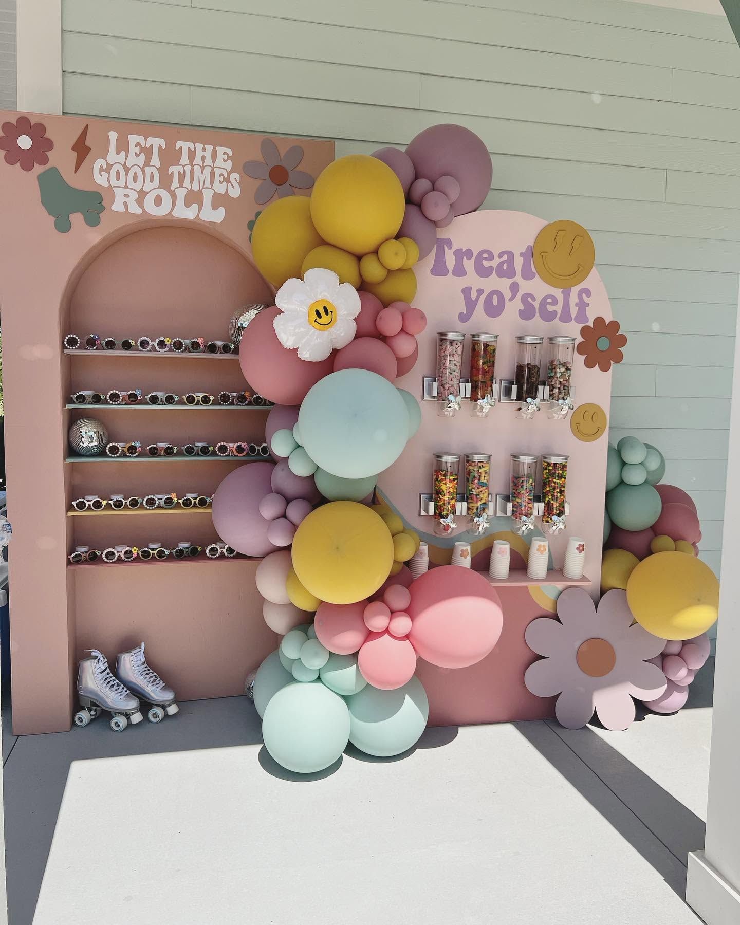 Pastel candy display with balloons and flowers, featuring shelves of treats and the sign Treat yo’ self.