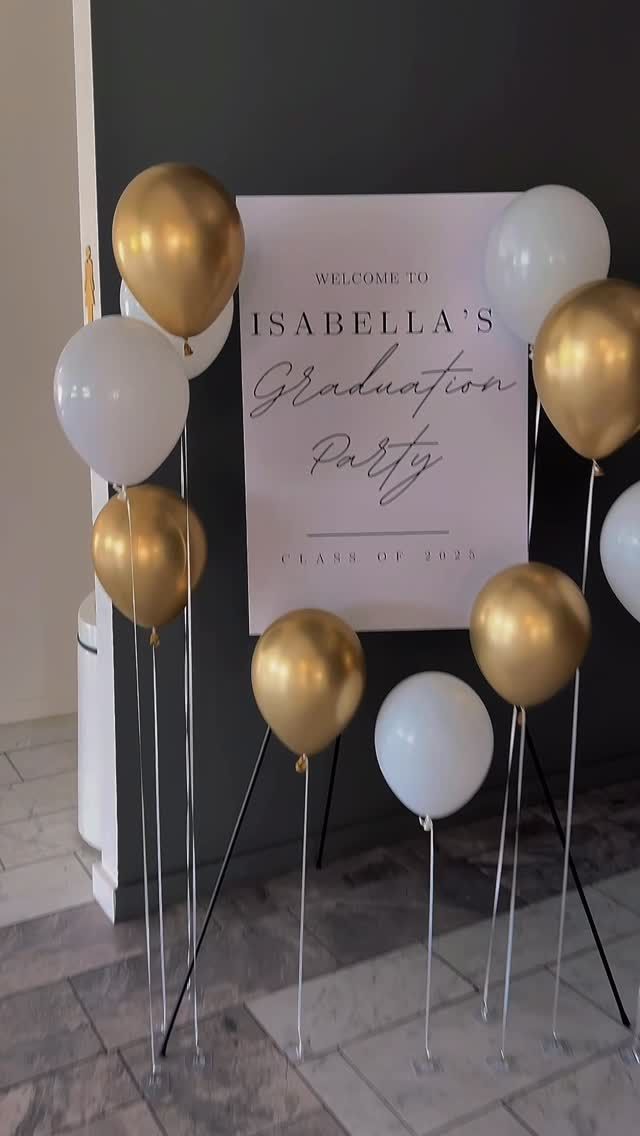 Balloon display with gold and white balloons around an event sign for Isbella’s party