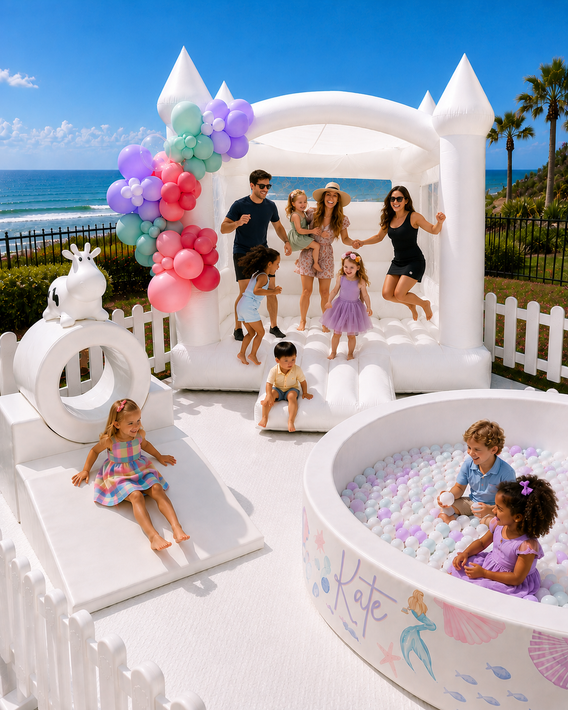 Pastel pink and white bounce house with flower decorations and Kolani banner outdoors under blue sky