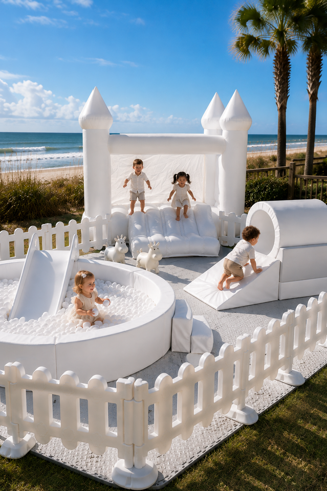 White inflatable backyard obstacle course with slide, fenced play area, and bounce house on a lawn