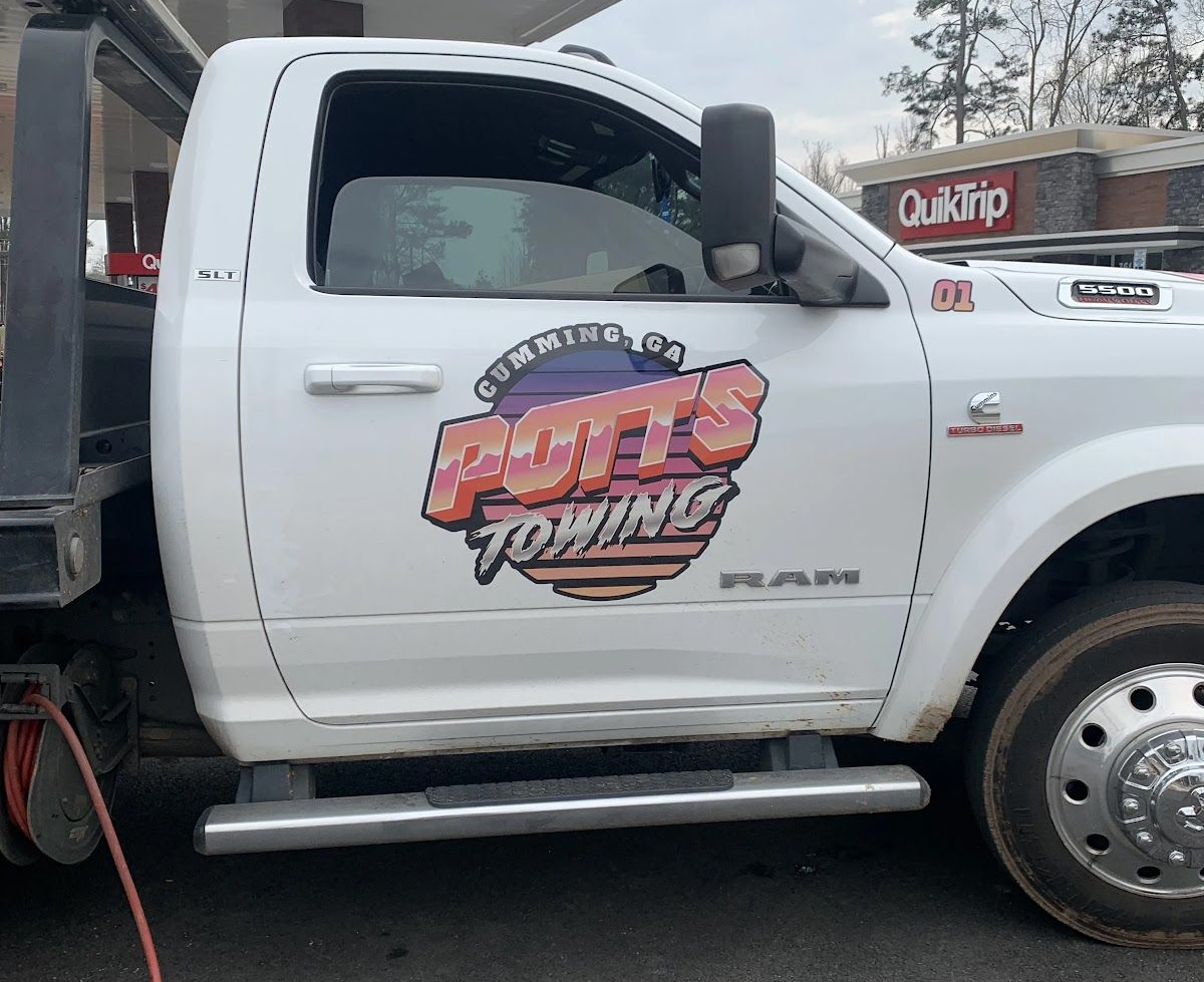 White towing truck with a colorful “Bump Towing” logo on the door, parked outdoors.