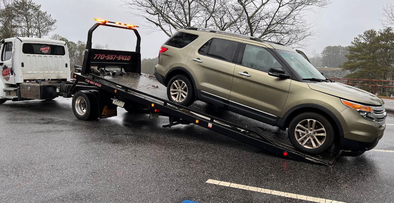 A car is being towed by a tow truck.