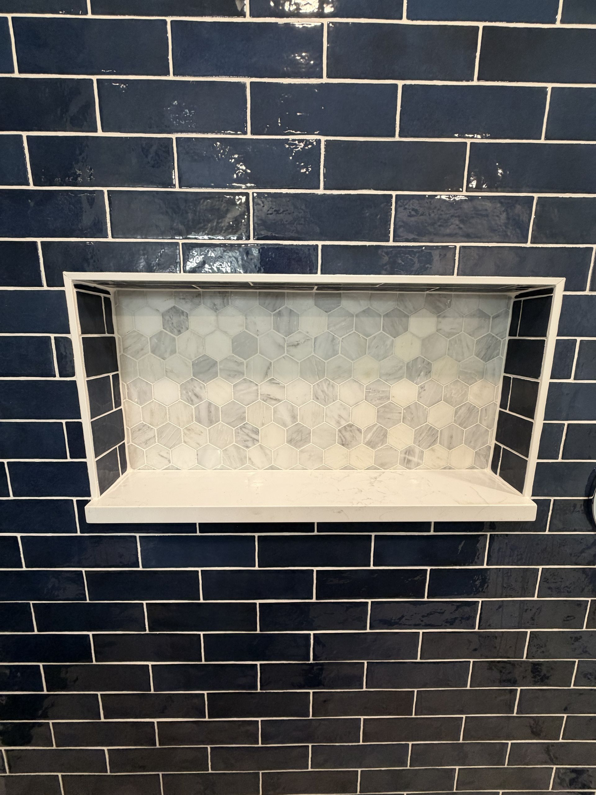 Blue subway-tile fireplace with a white interior and recessed opening