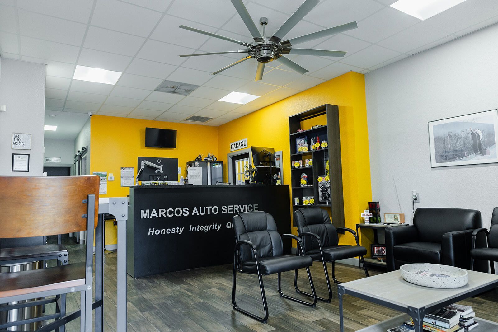 Interior of Marcos Auto Service waiting area: black counter, yellow wall, seating, ceiling fan. | Marcos Auto Service