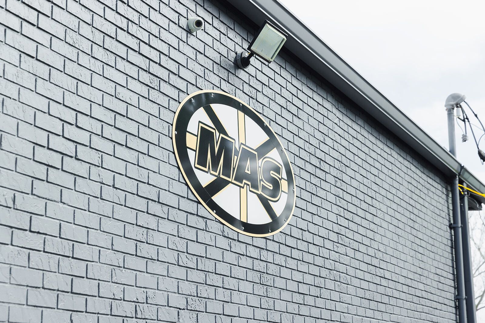 Black brick wall with a circular sign that reads