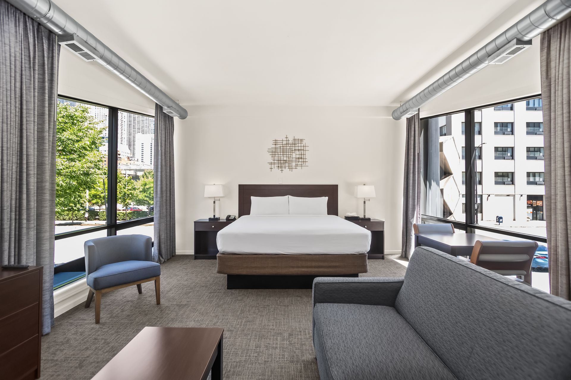 Spacious king guest room at Ohio House Motel Chicago with large windows, seating area and modern furnishings