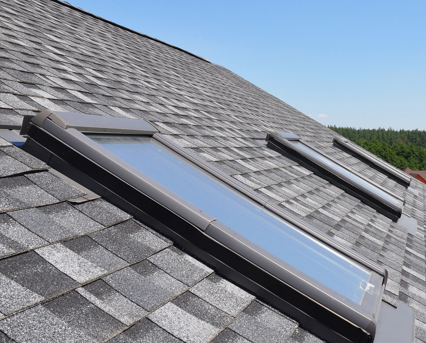 Red tile roof with two open skylights.