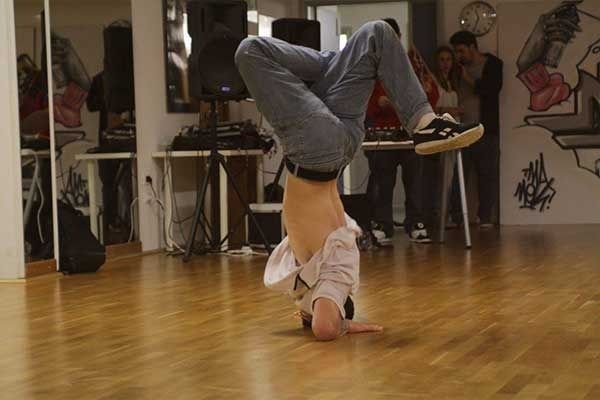 Persona che esegue una verticale su un pavimento di legno in una sala da ballo