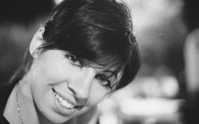 Donna sorridente dai capelli scuri in un ritratto ravvicinato in bianco e nero.