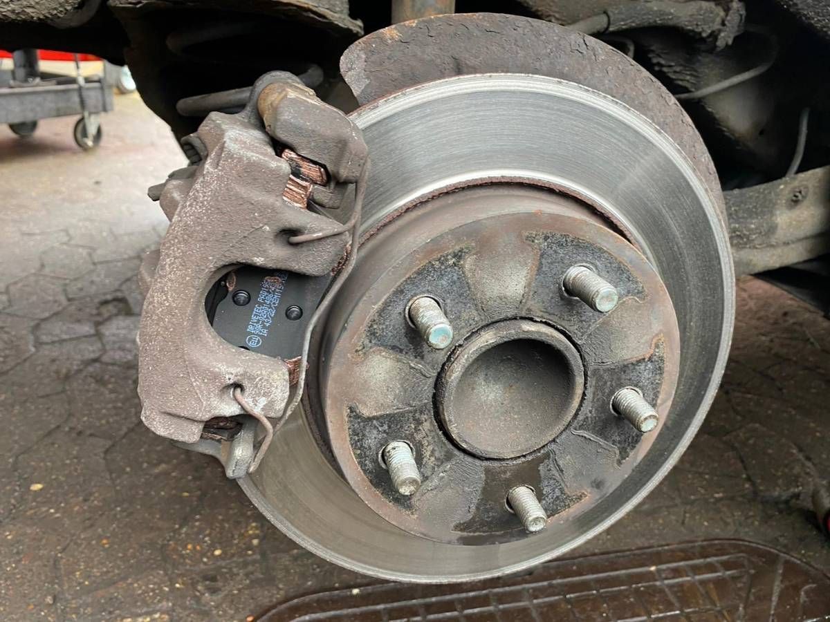 Rear brake caliper and disc on a Mazda with new brake pads fitted