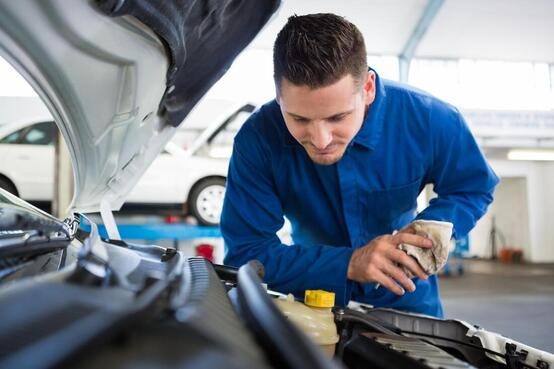Mechanic checking under the bonnet before starting work on a car