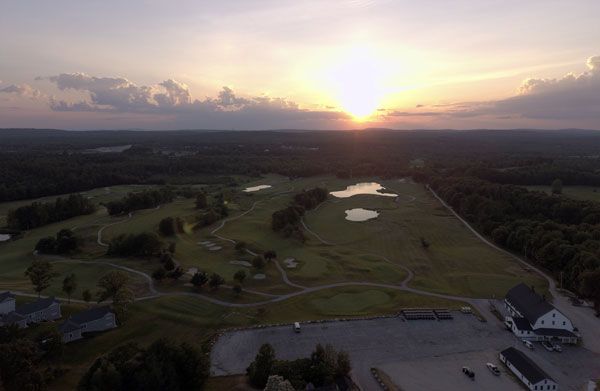 An aerial view of a golf course at sunset.