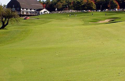 A golf course with a large house in the background