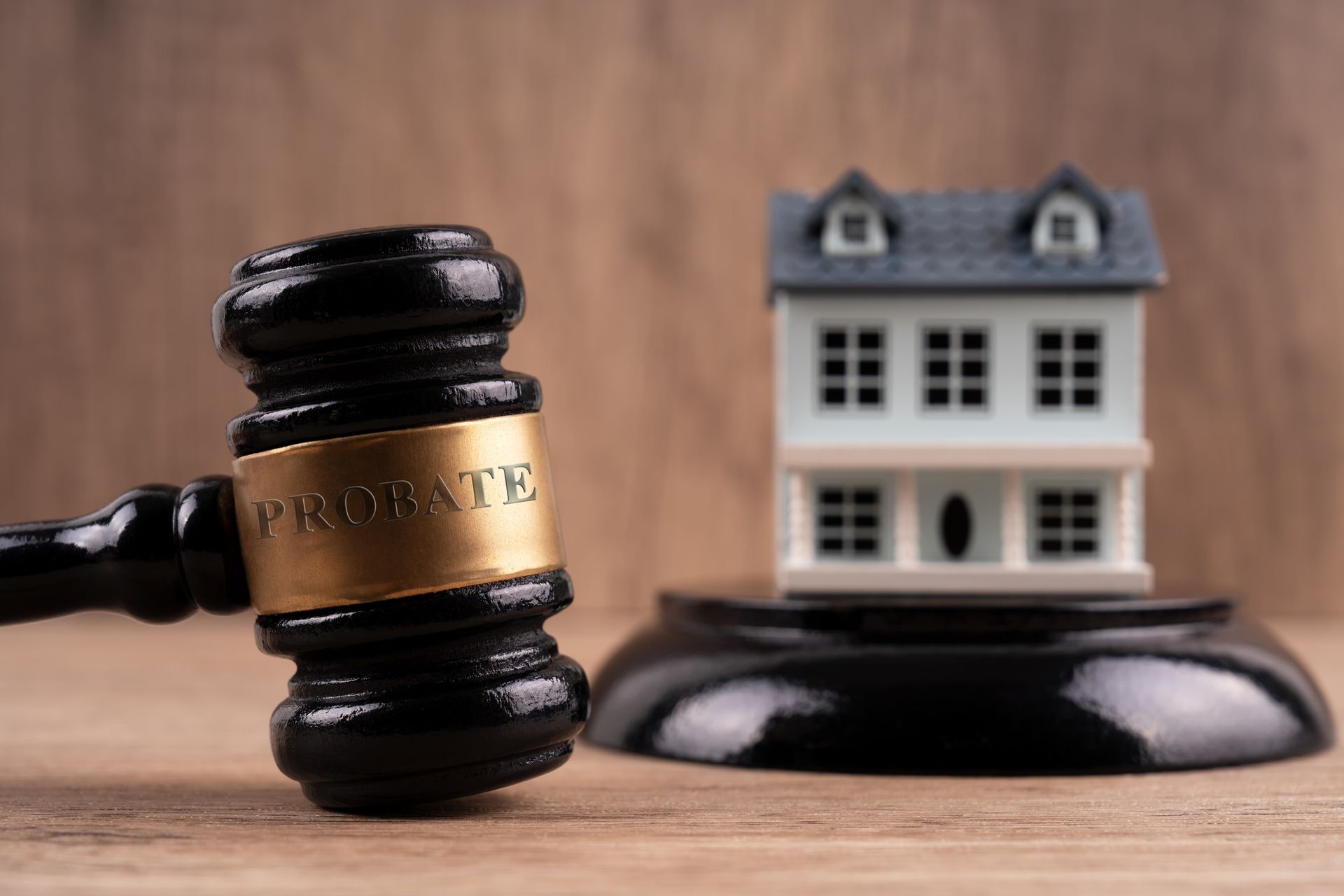 A gavel labeled 'Probate' next to a model house on a legal desk.