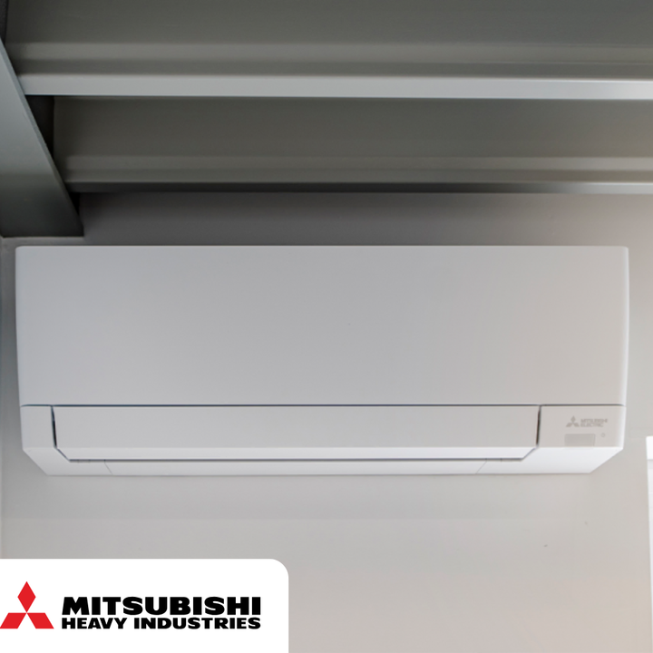 Witte Mitsubishi elektrische wandairconditioner aan het plafond, met logo linksonder.