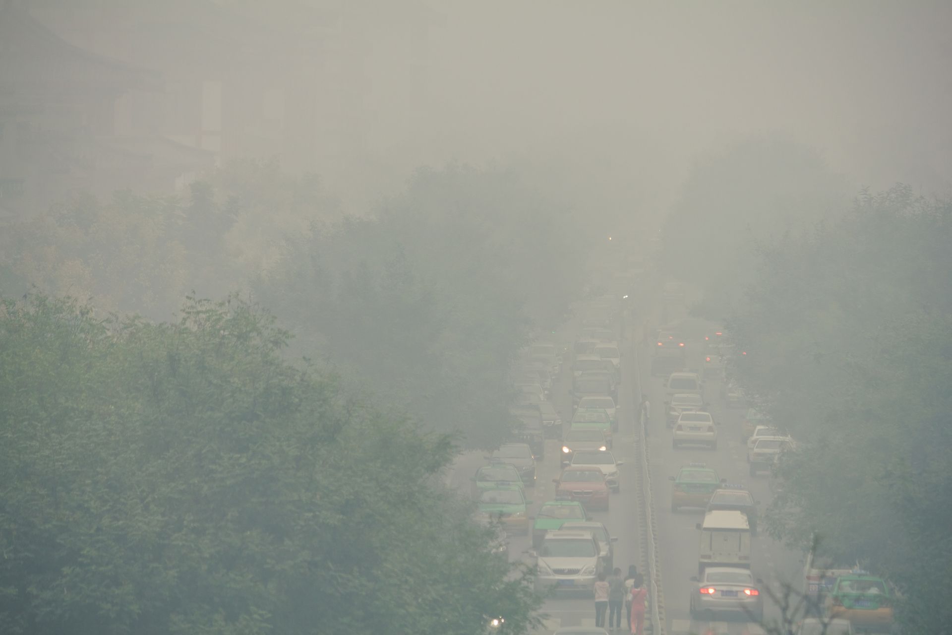 A traffic jam in a busy city, shadowed by a thick smog.