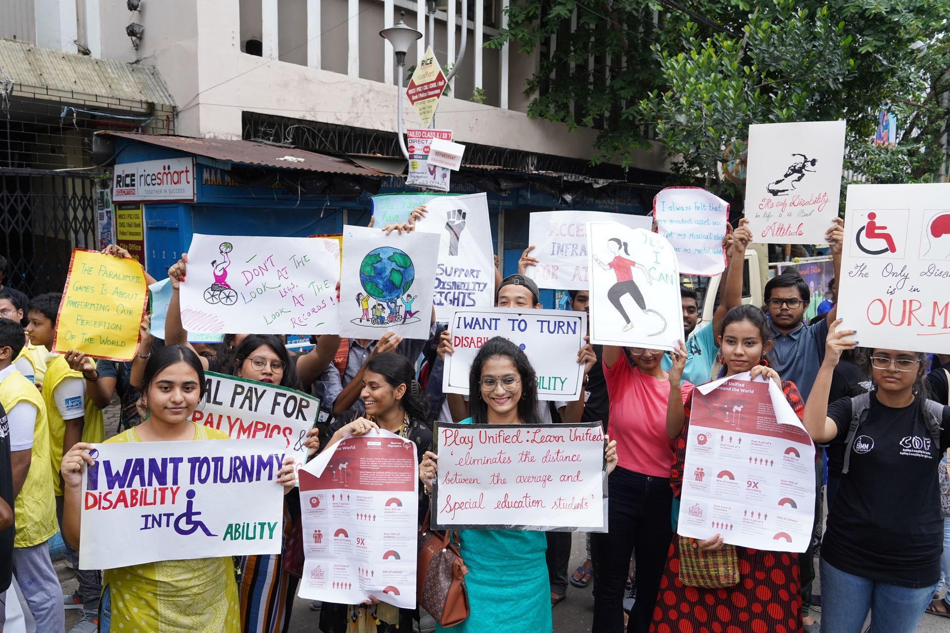 A group of activists hold up signs to protest for inclusivity with slogans such as 'I want to turn my disability into ability.'