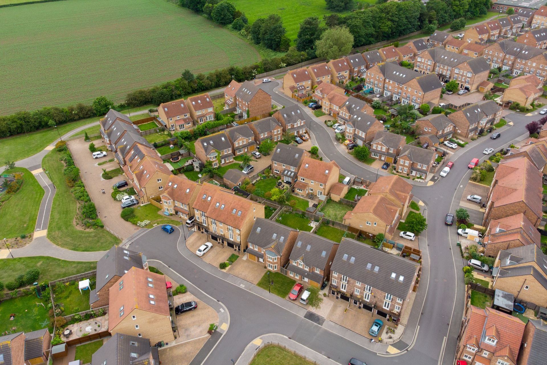 Aerial photograph of a newly constructed housing estate bordering the countryside.