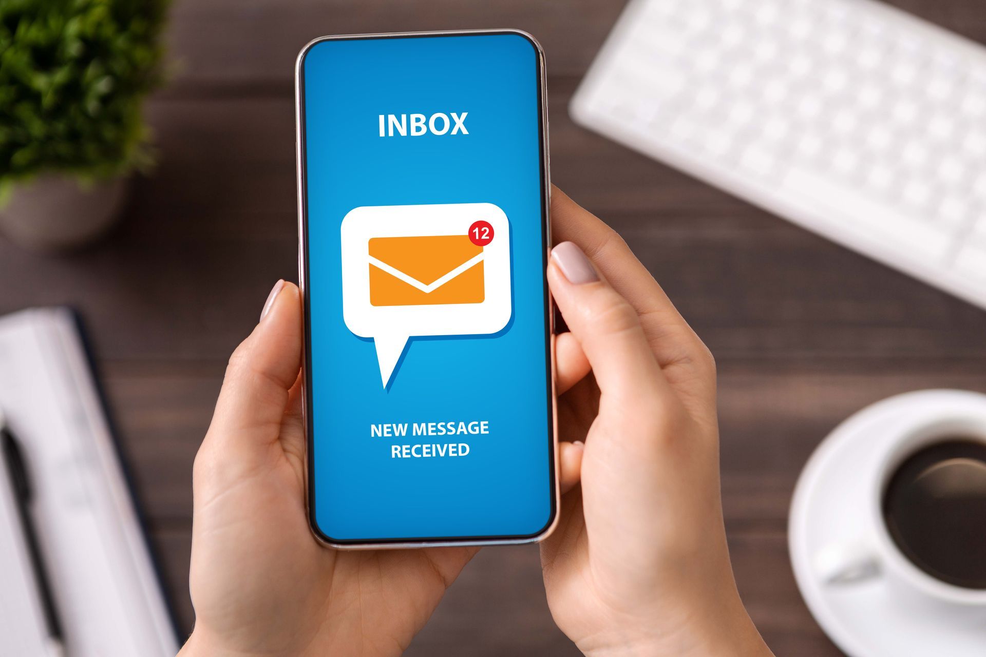 (Enhanced Communication) A phone screen pings with an email alert.