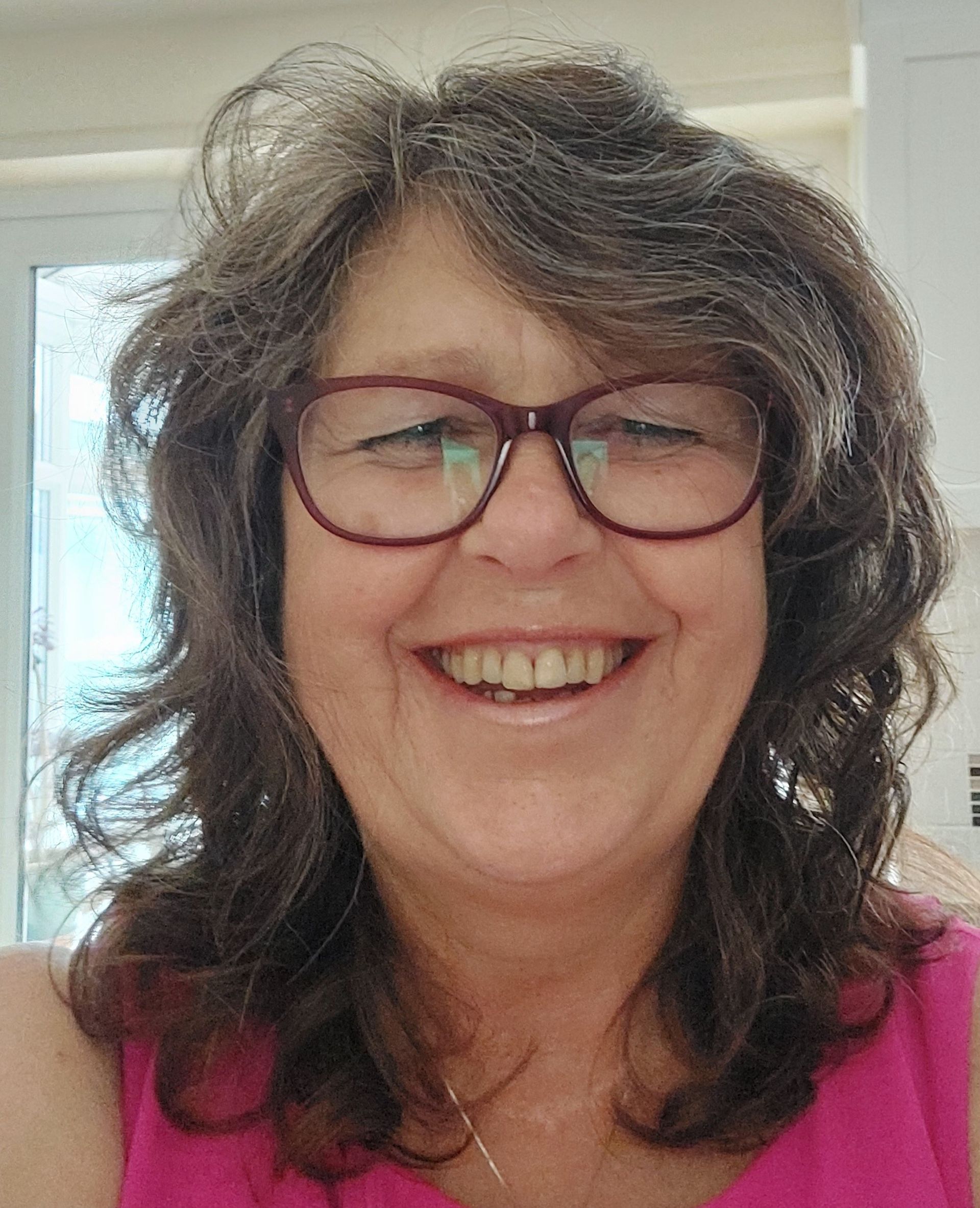 A picture of Angela Peak, a smiling woman with a bright and cheerful face.