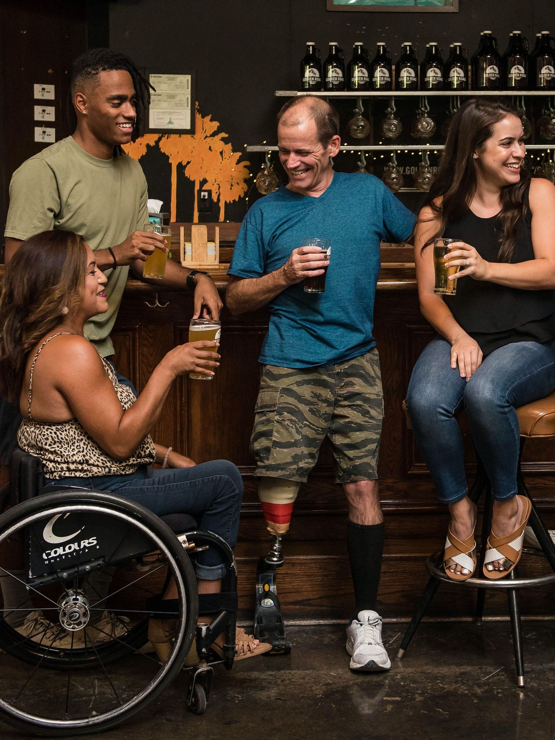 A group of friends with mixed abilities share a drink at a bar.