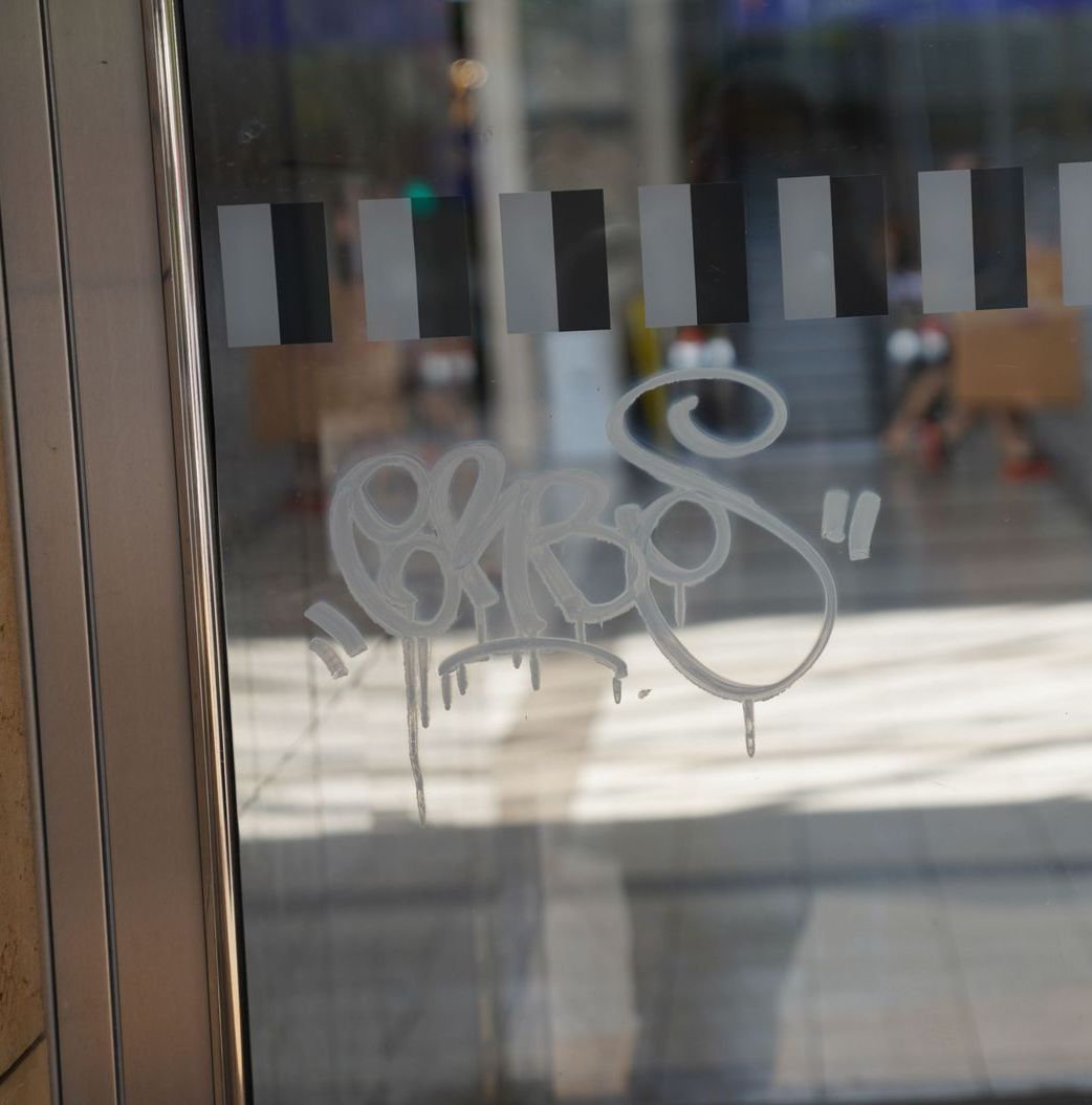 Eine Nahaufnahme einer Glastür mit Graffiti darauf